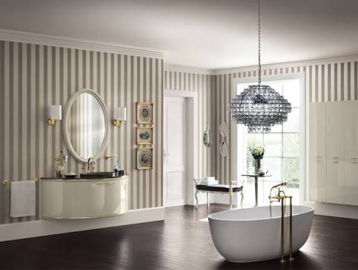 Lavabo bianco con rubinetti cromati, bottiglia scura e decorazioni su mensola, sfondo con piastrelle geometriche.